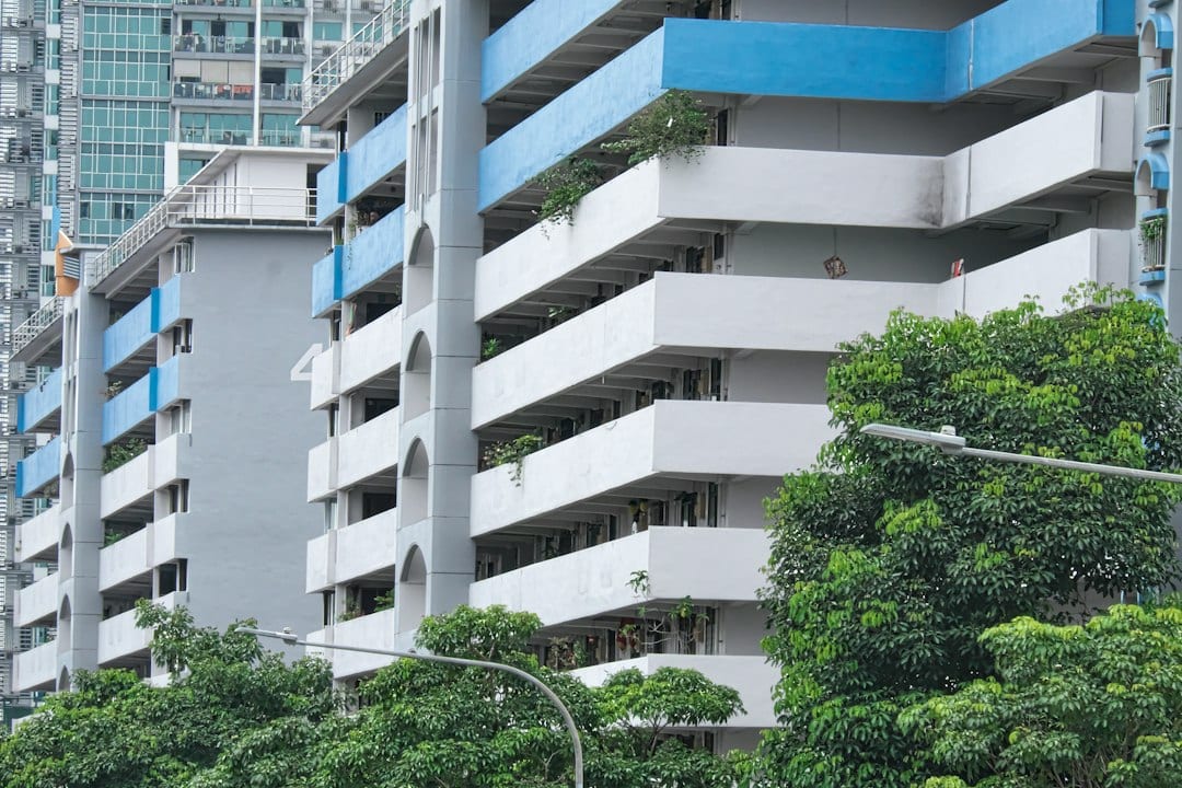 Tall residential condominium building with balconies and trees in Marine Parade, East Coast